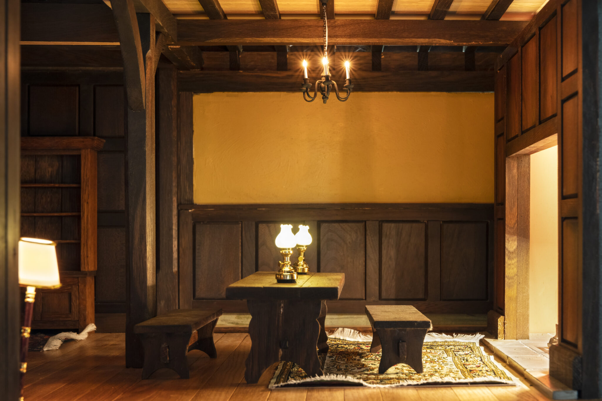 Open-concept kitchen featuring a wooden table with lamps and a view of the living room.